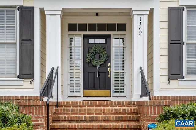 entrance to property featuring brick siding