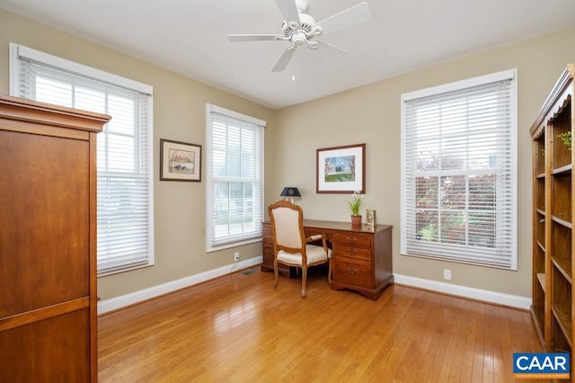 office space featuring light wood finished floors, baseboards, and a ceiling fan