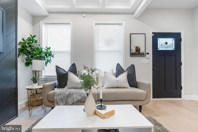 living room featuring light wood-style floors, coffered ceiling, crown molding, and baseboards