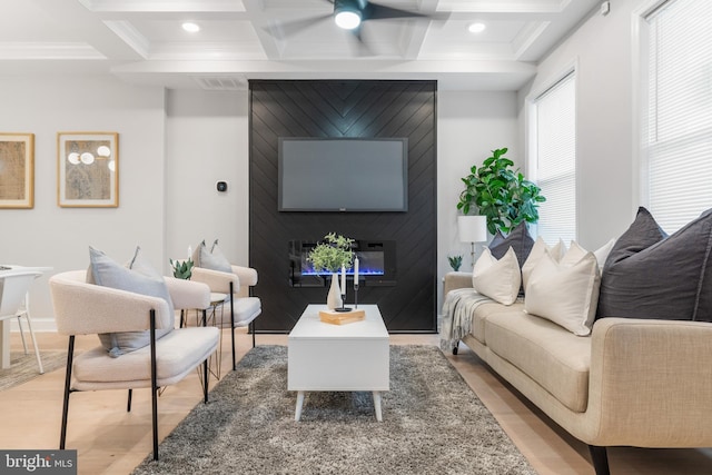 living area featuring visible vents, a fireplace, coffered ceiling, and light wood-style flooring