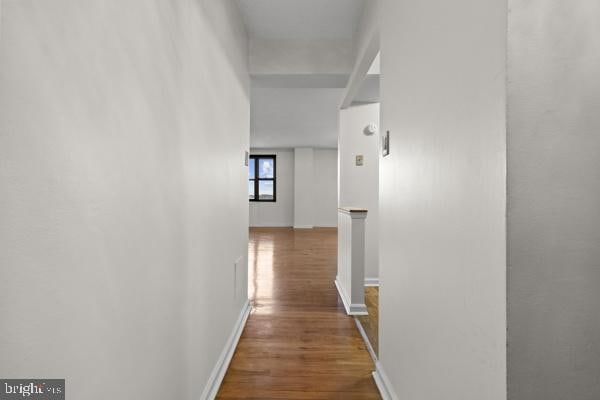 hallway with baseboards and wood finished floors