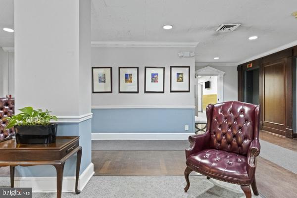 living area with recessed lighting, visible vents, crown molding, and baseboards