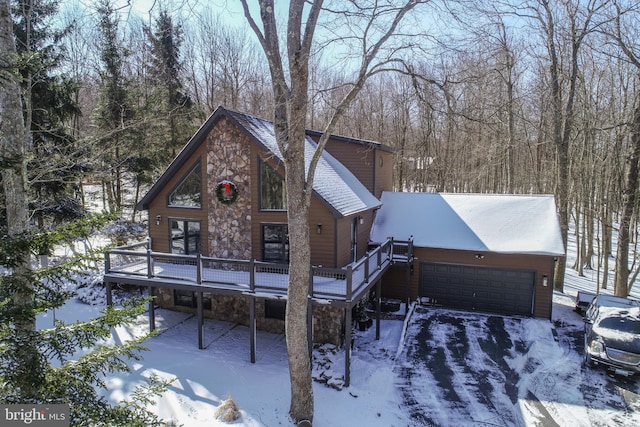 rustic home featuring a garage, stone siding, and a wooden deck