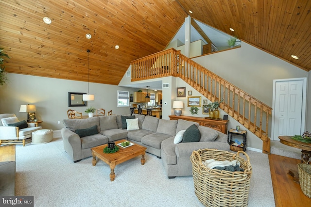 living room with baseboards, wood ceiling, wood finished floors, stairs, and high vaulted ceiling