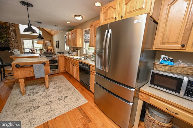 kitchen with a healthy amount of sunlight, appliances with stainless steel finishes, light countertops, and pendant lighting