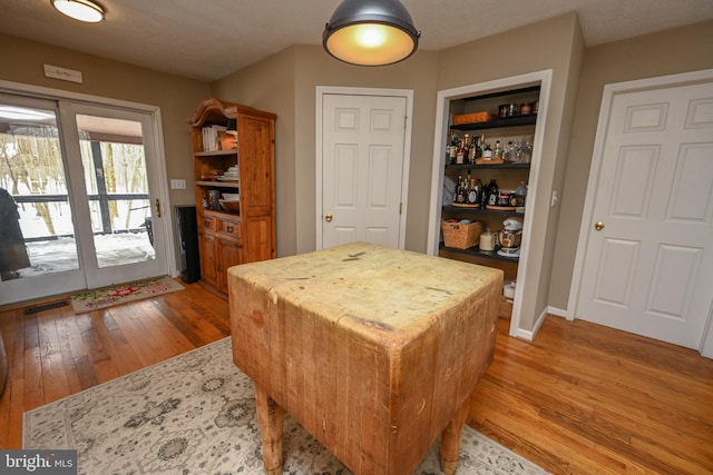 interior space with light wood-style flooring, a center island, light countertops, and visible vents