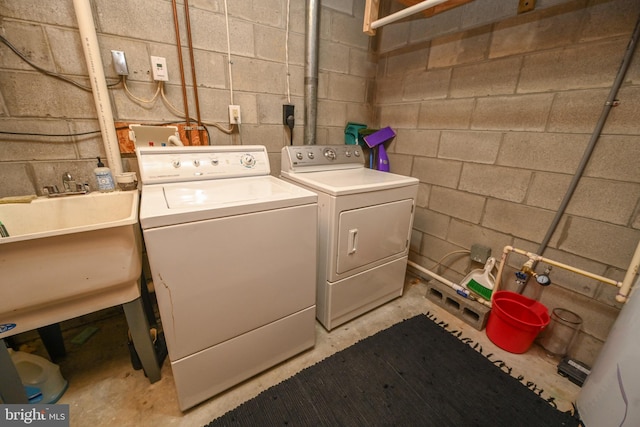 laundry area with laundry area, washer and clothes dryer, and concrete block wall