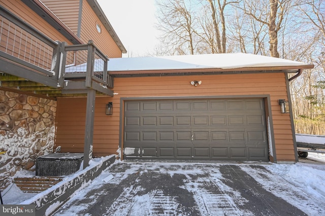 snow covered garage featuring central AC unit