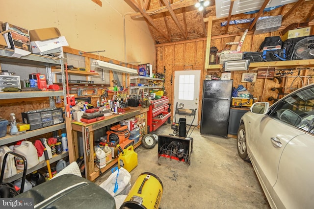 garage with a workshop area and freestanding refrigerator