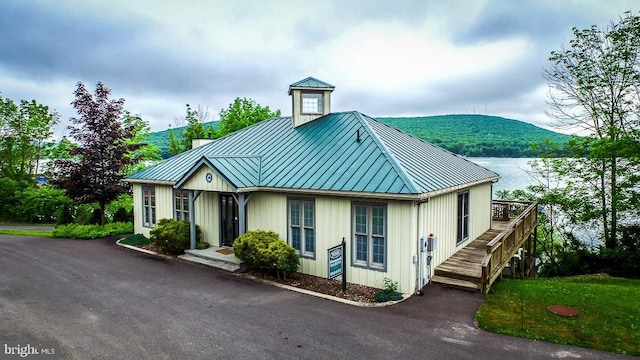 view of front of home featuring board and batten siding, a standing seam roof, metal roof, and a water and mountain view