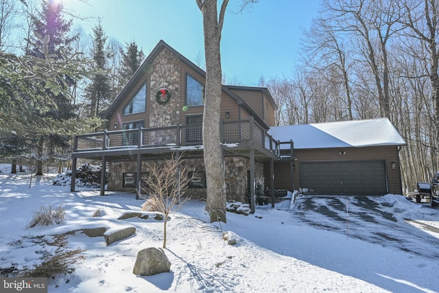 rustic home with an attached garage, stone siding, and a deck