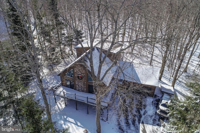 view of snowy exterior with stone siding