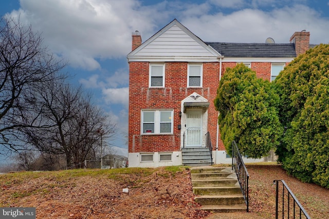 view of front of property with brick siding and a chimney