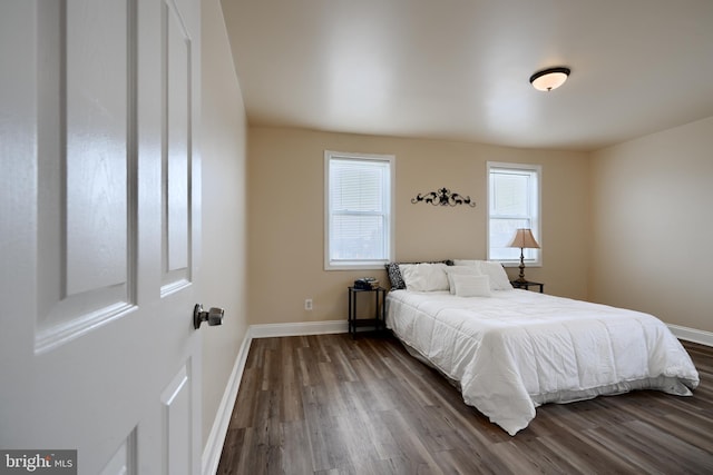 bedroom featuring dark wood-type flooring and baseboards