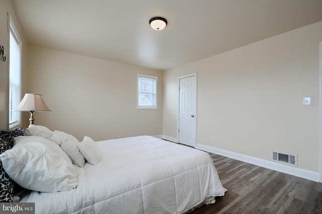 bedroom featuring dark wood-type flooring, visible vents, and baseboards