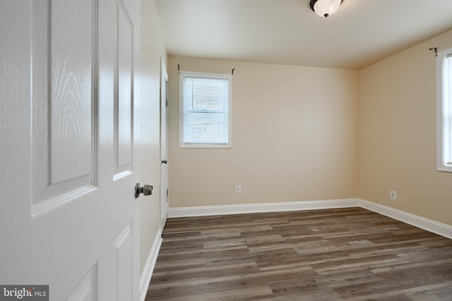 unfurnished room featuring baseboards and wood finished floors