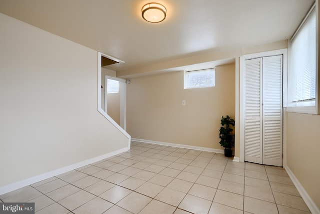 below grade area featuring light tile patterned flooring and baseboards