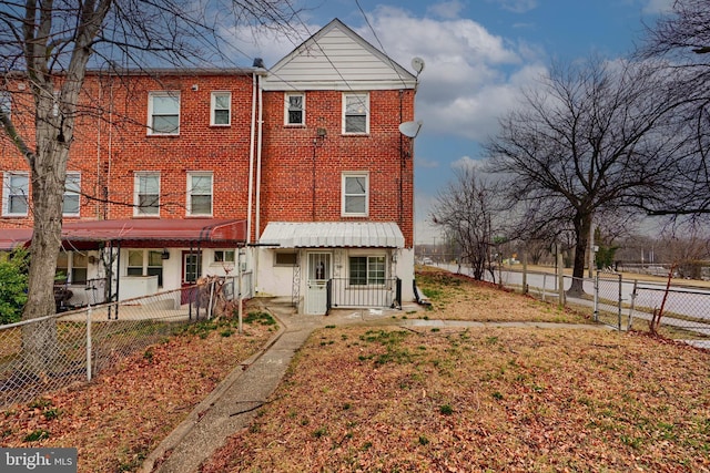 view of front of property featuring brick siding and a fenced backyard