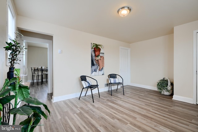 living area featuring light wood finished floors and baseboards