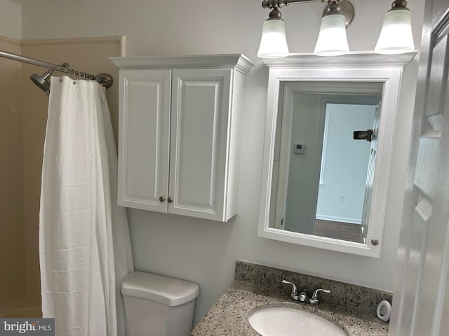 bathroom featuring toilet, shower / bath combo with shower curtain, and vanity