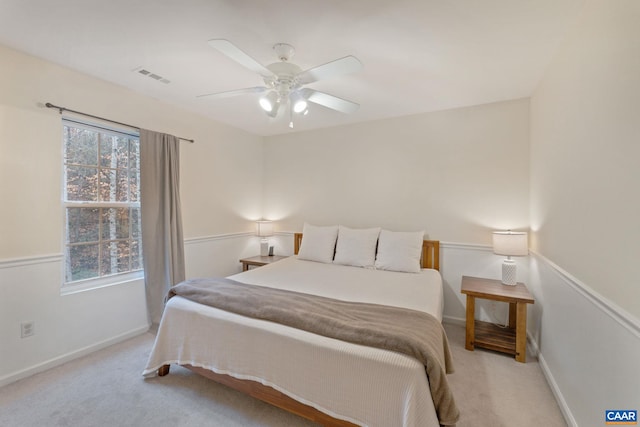 bedroom with baseboards, visible vents, ceiling fan, and light colored carpet