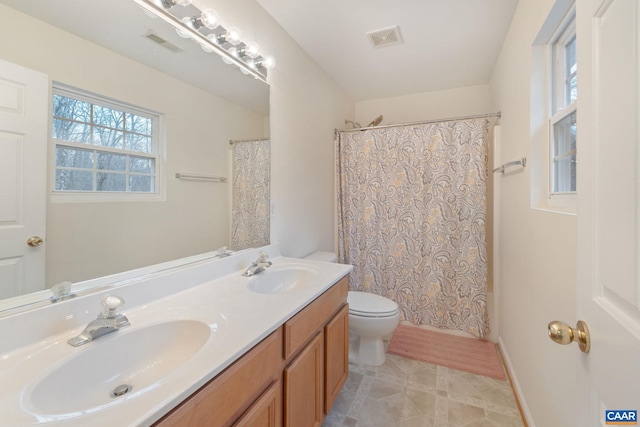 bathroom with toilet, visible vents, and a sink