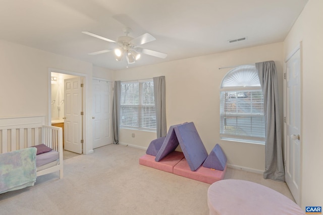 playroom with a healthy amount of sunlight, ceiling fan, light carpet, and visible vents