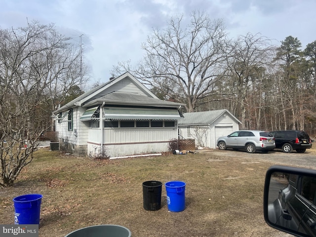 view of front of home with an outdoor structure, cooling unit, and a front yard