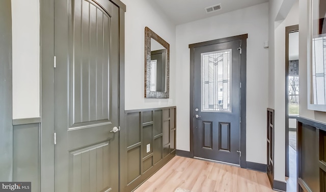 entryway with light wood-type flooring, visible vents, and baseboards