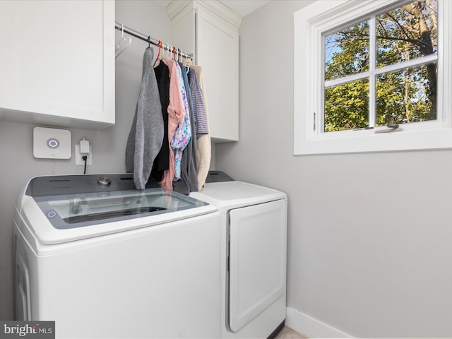 washroom with cabinet space, baseboards, and washer and clothes dryer