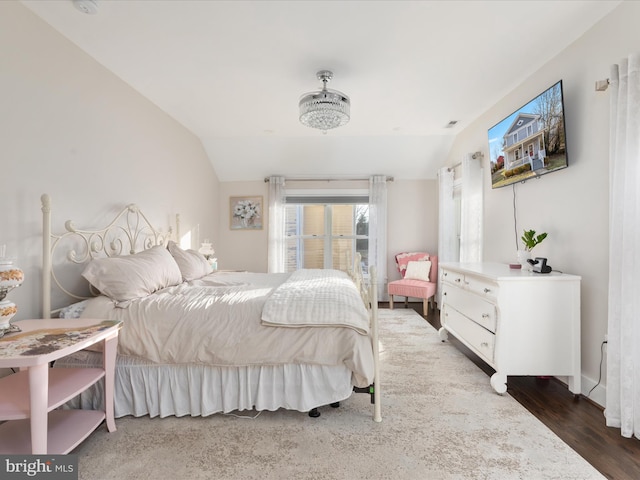 bedroom with lofted ceiling and wood finished floors