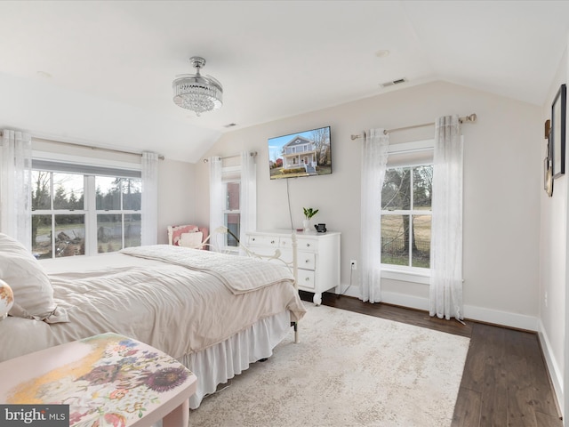 bedroom featuring lofted ceiling, baseboards, visible vents, and wood finished floors