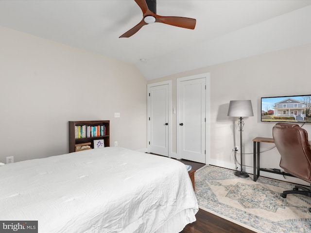 bedroom featuring lofted ceiling, dark wood-type flooring, and a ceiling fan