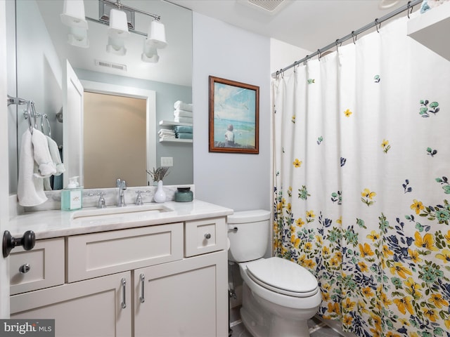 bathroom featuring toilet, a shower with curtain, visible vents, and vanity