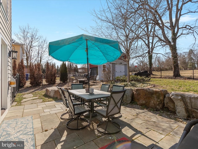 view of patio with a fenced backyard, an outdoor structure, and outdoor dining space