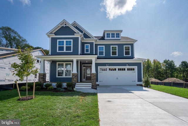 craftsman house with an attached garage, concrete driveway, and a front yard