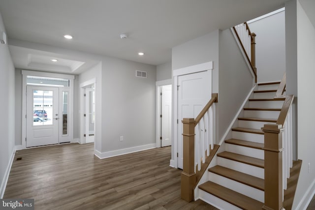 foyer featuring visible vents, baseboards, wood finished floors, and recessed lighting