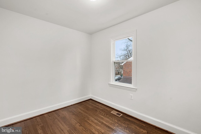 unfurnished room with visible vents, baseboards, and wood finished floors