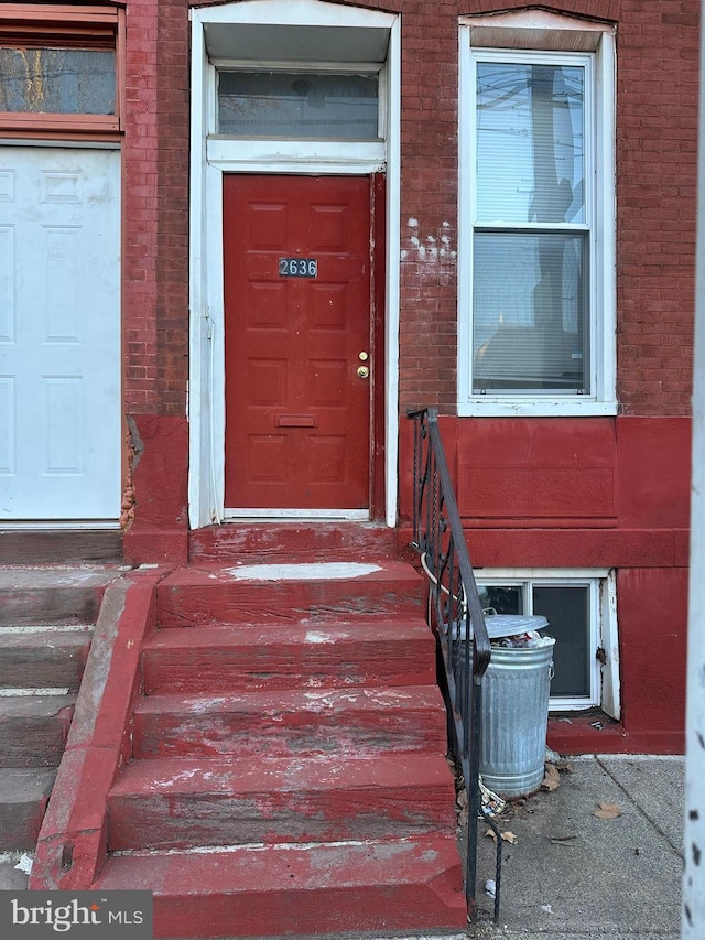 entrance to property featuring brick siding