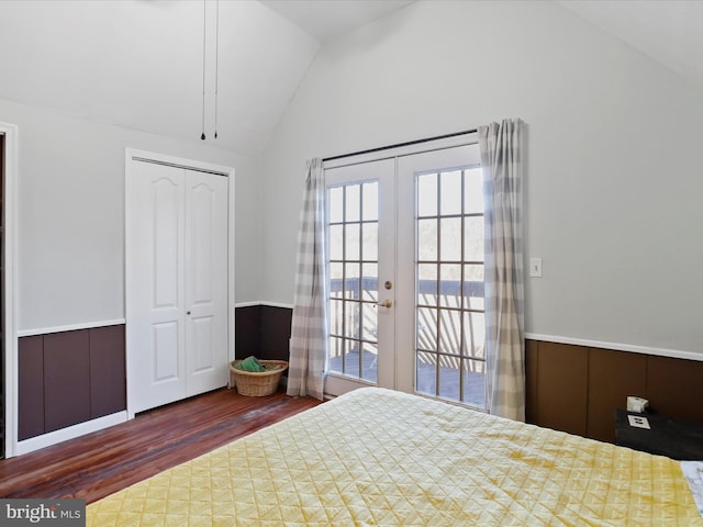 unfurnished bedroom featuring lofted ceiling, access to outside, french doors, wainscoting, and dark wood finished floors