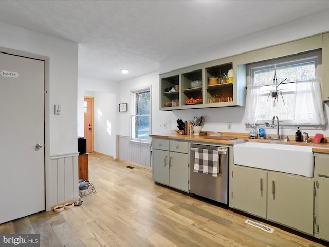 kitchen featuring visible vents, dishwasher, wainscoting, light countertops, and a wealth of natural light