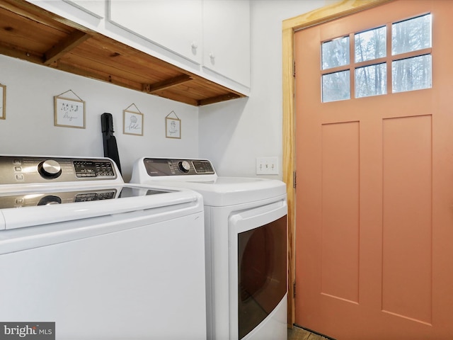 washroom with cabinet space and separate washer and dryer