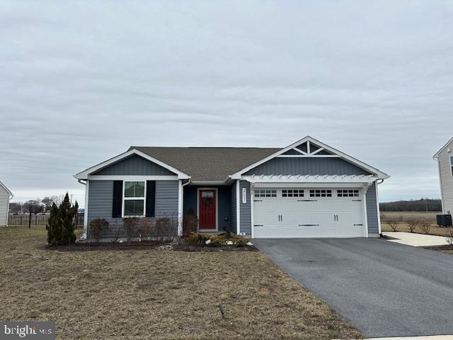 ranch-style house with a garage, driveway, a front lawn, and board and batten siding