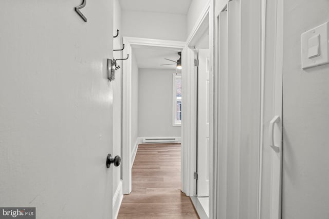 hall featuring light wood-style floors and a baseboard heating unit