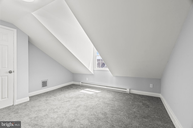 additional living space with visible vents, baseboards, vaulted ceiling, carpet floors, and a baseboard heating unit