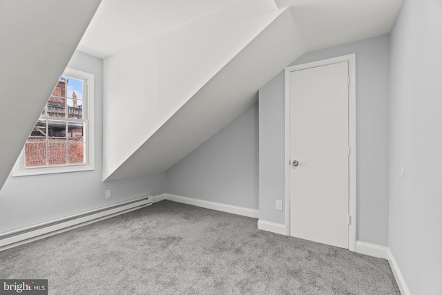 bonus room with a baseboard heating unit, vaulted ceiling, baseboards, and light colored carpet