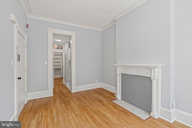 unfurnished living room featuring ornamental molding, light wood-type flooring, and baseboards