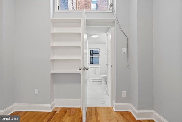 interior space with baseboards and wood finished floors