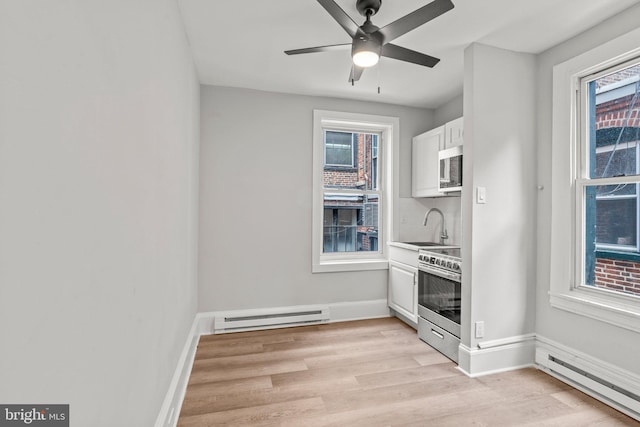 kitchen featuring light wood-style floors, a baseboard radiator, white cabinets, and electric stove