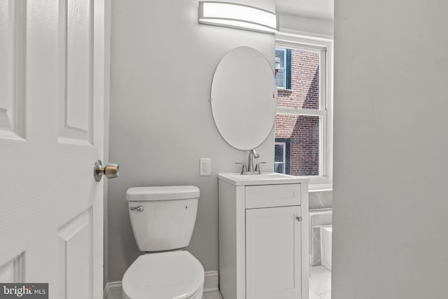 bathroom featuring baseboards, vanity, and toilet